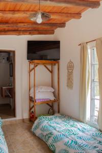 um quarto com uma cama e uma televisão num quarto em Monoambiente Golondrina em Capilla del Monte