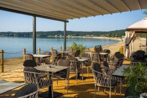 a restaurant on the beach with tables and chairs at Olive Villas Beach Hotel in Sozopol