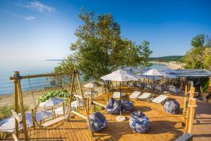 a group of chairs and umbrellas on a beach at Olive Villas Beach Hotel in Sozopol