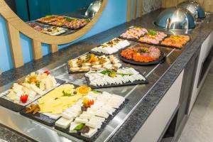 a buffet line with different types of cheese and appetizers at Olive Villas Beach Hotel in Sozopol
