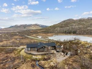 een luchtzicht op een huis op een heuvel met een meer bij Romslig hytte med natur og gode fiskemuligheter! in Lødingen