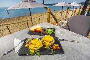 ein Teller mit Essen auf einem Tisch am Strand in der Unterkunft Olive Villas Beach Hotel in Sozopol