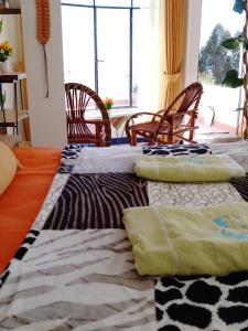 2 camas en una habitación con sillas en Jardín Andino hostal en Copacabana