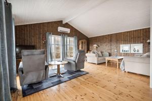a living room with two chairs and a couch at Romslig hytte med natur og gode fiskemuligheter! in Lødingen