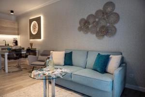 uma sala de estar com um sofá azul e uma mesa em Platinium Moon - przy samym morzu - Easy-Rent Apartments em Rewal