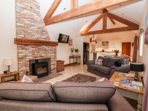 a living room with a couch and a fireplace at Mistal Cottage in Husthwaite