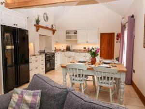 a kitchen with a table and chairs in a kitchen at Mistal Cottage in Husthwaite