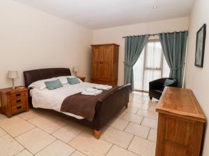 a bedroom with a bed and a desk and a chair at Mistal Cottage in Husthwaite