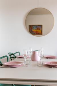 una mesa con platos rosas y copas de vino en SUNSHINE - Appartement 2pers - terrasse vue mer - Dinard, en Dinard