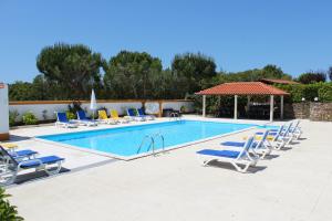 a swimming pool with lounge chairs and a group at Casa de Campo Sao Rafael - Turismo Rural in Óbidos