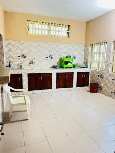 a kitchen with a white tiled floor and a counter at Spacieuse maison à Calavi - Comme chez vous in Abomey-Calavi