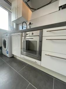 een keuken met een fornuis, een wasmachine en een droger bij Sunny and spacious apartment in Rotterdam