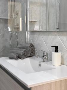 lavamanos con toallas y grifo en Casa Vacanze Maride, en Capitana