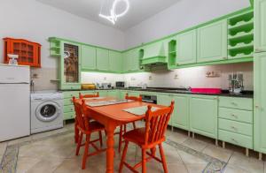 a kitchen with green cabinets and a table and chairs at Ta' Marija Home in Sliema