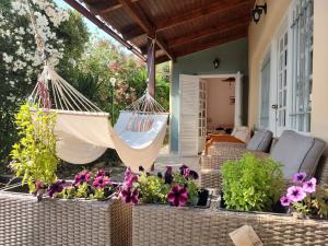 a swinging hammock on a patio with flowers at Anatolika Stamatis Paradise in Dhémbla