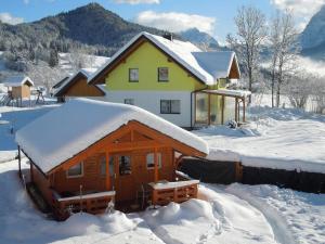 a house with snow on the roof of it at Ferienhäuschen Nationalpark Gesäuse in Admont