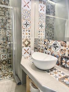 a bathroom with a sink and tiles on the wall at D'Angiò Rooms-Manfredi Homes&Villas in Manfredonia