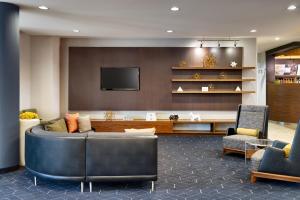 a living room with a couch and a tv at Courtyard by Marriott Houston NASA Clear Lake in Nassau Bay