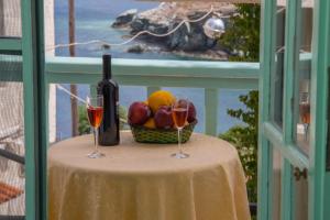 a table with two glasses of wine and a basket of fruit at Mary's Studios in Agia Pelagia