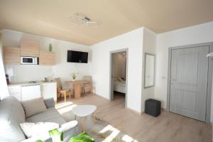 a white living room with a couch and a kitchen at Gästehaus COCO in Krems an der Donau