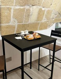 una mesa negra con un plato de comida. en Glamour suite, en Gravina in Puglia