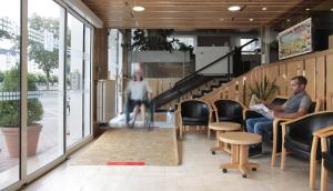 a man sitting in a chair in a office with a laptop at Hôtel Sainte Suzanne in Lourdes