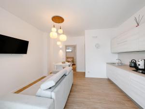 uma sala de estar branca com um sofá branco e uma cozinha em Villa Angelica - Casa Vacanze em Reggio di Calabria