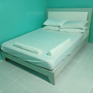 faTuur Inn في مدينة ماليه: سرير عليه أغطية ووسائد بيضاء