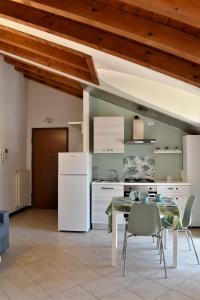 Gussago的住宿－La mansarda，厨房配有桌子和白色冰箱。