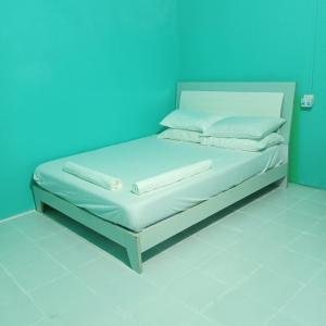un letto in una camera con parete blu di faTuur Inn a Città di Malé