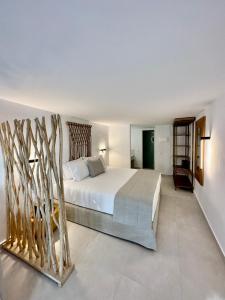 a bedroom with a white bed and some trees at Sofos Suites Mykonos in Mikonos