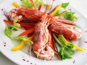 a plate of food with shrimp and vegetables on it at Hotel La Pigna in Marina di Pietrasanta