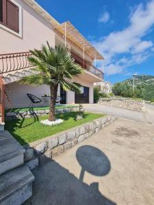 a palm tree in front of a house at Ston apartment Sagittarius in Ston