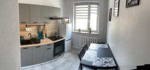 a kitchen with a table and a sink and a stove at Apartament Reszel in Reszel