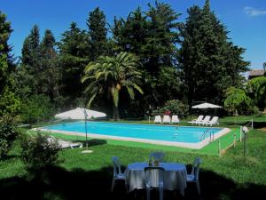 a swimming pool with tables and chairs in a yard at Agriturismo Feudo Tudia in Resuttano