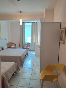 Hotel Lo Smeraldo في Roccavivara: غرفة فندقية بسريرين وكرسي