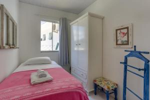 a bedroom with a bed and a dresser and a window at Apart Carolina in Florianópolis