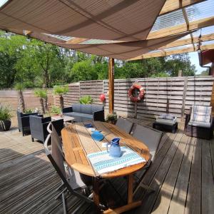 a wooden table under an umbrella on a deck at Blue Ocean in Moliets-et-Maa