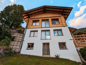 a house with a wooden roof on a hill at Das Wipferl - Dein Nest in den Bergen in Maria Luggau