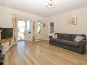 a living room with a couch and a television at Seagull Cottage in Holyhead