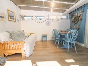 a room with a bed and a table and chairs at Seagull Cottage in Holyhead