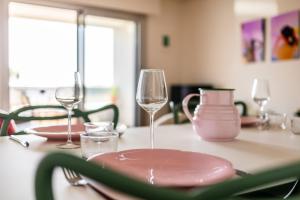 - une table avec deux verres à vin et des assiettes dans l'établissement SUNSHINE - Appartement 2pers - terrasse vue mer - Dinard, à Dinard