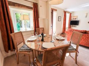 a dining room with a table and chairs and a couch at 4 Greencross Cottages in Holme