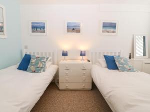 two beds sitting next to each other in a bedroom at 11 Min Y Mor in Pwllheli