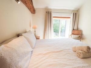 a bedroom with a large white bed with a window at 4 Greencross Cottages in Holme