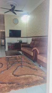 uma sala de estar com dois sofás e uma mesa em Anjung KLIA House 31 With Neflix & Airport Shuttle em Banting