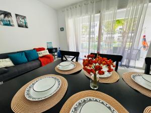 a living room with a table with plates and flowers on it at Beautiful Apartment in Estrella Dominicus Bayahibe in Bayahibe