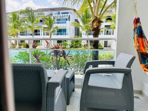 a balcony with chairs and a view of a building at Beautiful Apartment in Estrella Dominicus Bayahibe in Bayahibe