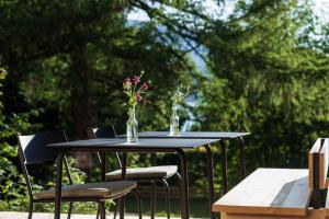 ein schwarzer Tisch mit einer Vase Blumen drauf in der Unterkunft Blyb Hotel in Gmund am Tegernsee