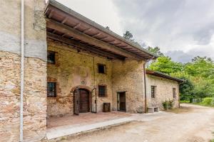 un antiguo edificio de piedra con una puerta grande en Frantoio Del Moscatello en Camaiore